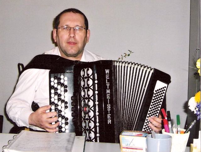 Der Akkordeonspieler spielt an einem Tisch.